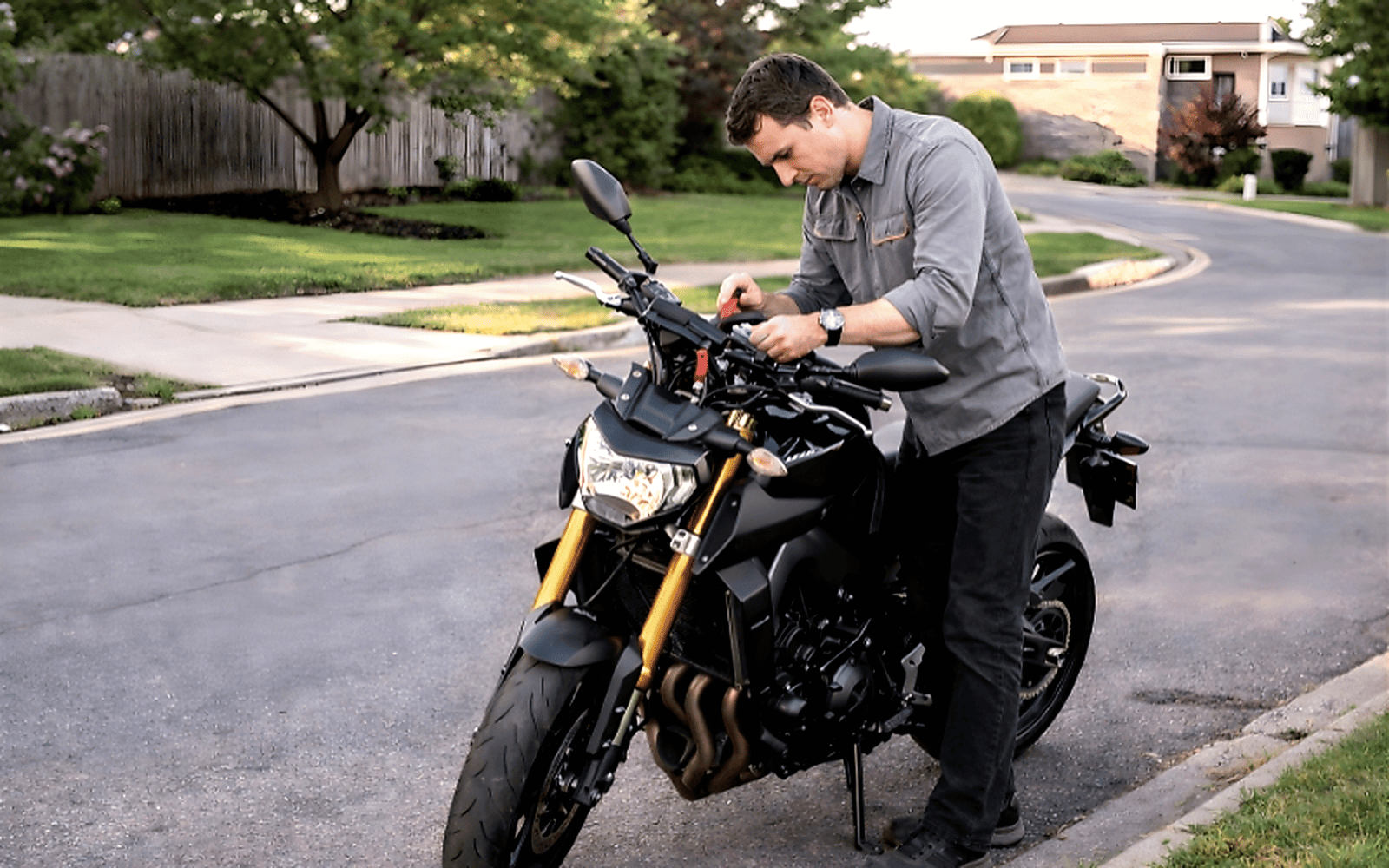 Professional motorcycle locksmith repairing bike ignition on the road during emergency service call
